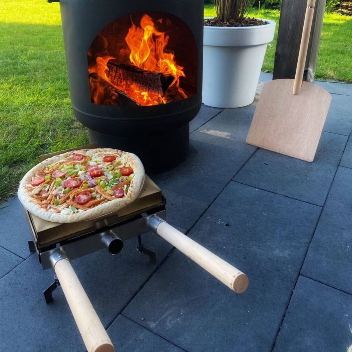 Pizzasteen met handvaten in een tuinhaard voor buiten